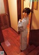 A woman standing in a room with a wooden floor.