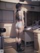 A woman in a white bikini and black boots standing in a kitchen.