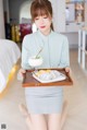 A woman holding a tray with food on it.