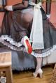 A woman in a black and white dress and red shoes.