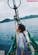 A woman standing on the back of a boat looking up at the sky.