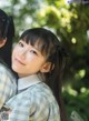 A young girl with long black hair and a plaid shirt.