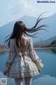 A woman standing in front of a body of water.