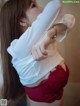 A woman in a white shirt and red panties.